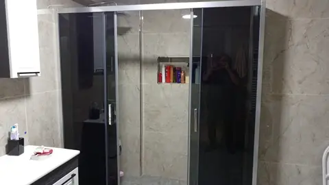 Bej mermer desenli seramikle yenilenen banyo, siyah camlı duşakabin ve lavabo dolabı