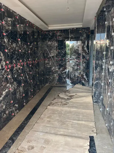 Siyah mermer desenli duvar seramiğiyle kaplanan uzun koridor, uygulama aşaması