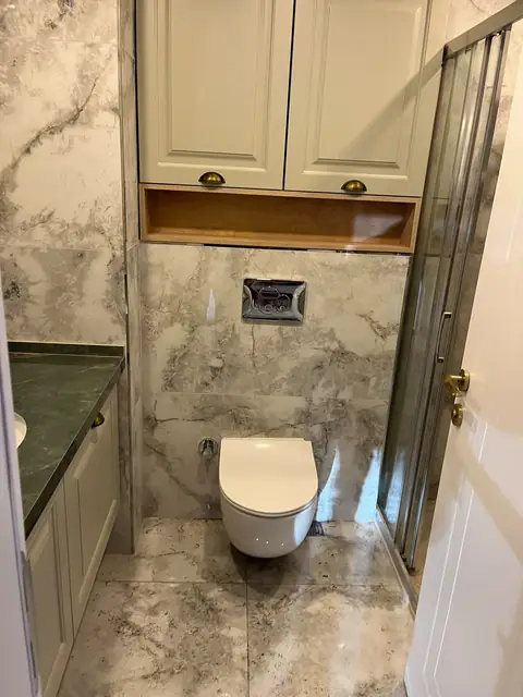 Tamamlanmış banyo: asma klozet, mermer desenli duvar ve zemin seramiği