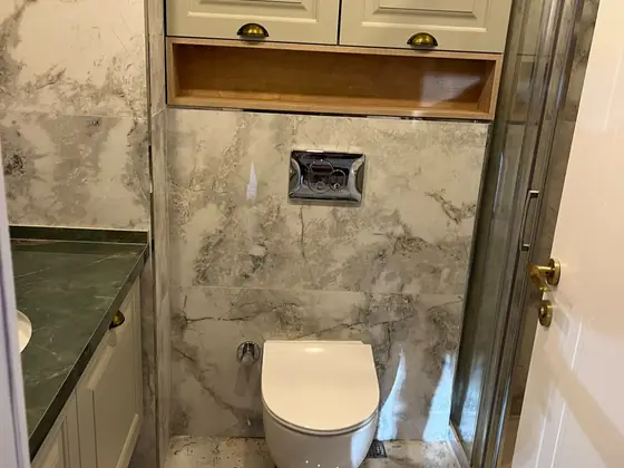 Tamamlanmış banyo: asma klozet, mermer desenli duvar ve zemin seramiği